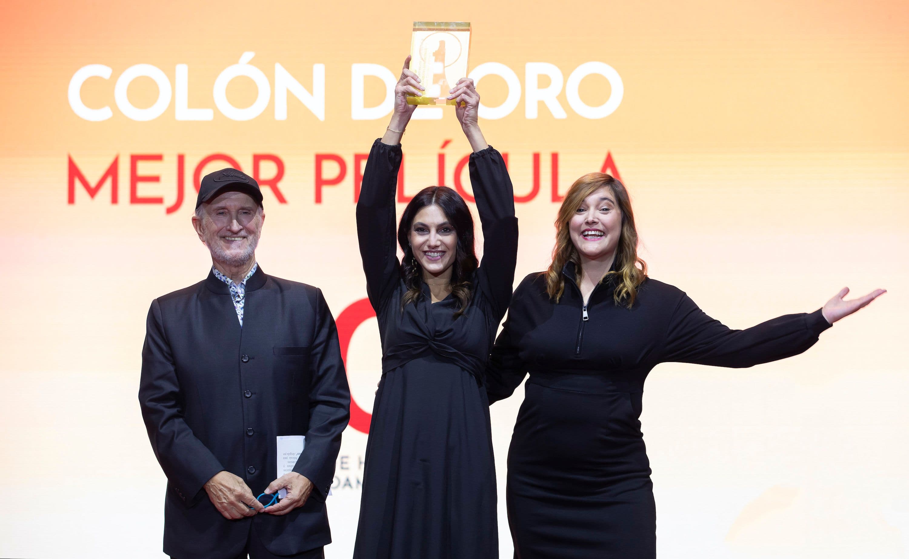 La actriz Wafa'a Halawi sostiene el Colón de Oro 2024 junto a Javier Angulo, presidente del jurado, y la programadora Ivonne Cotorruelo