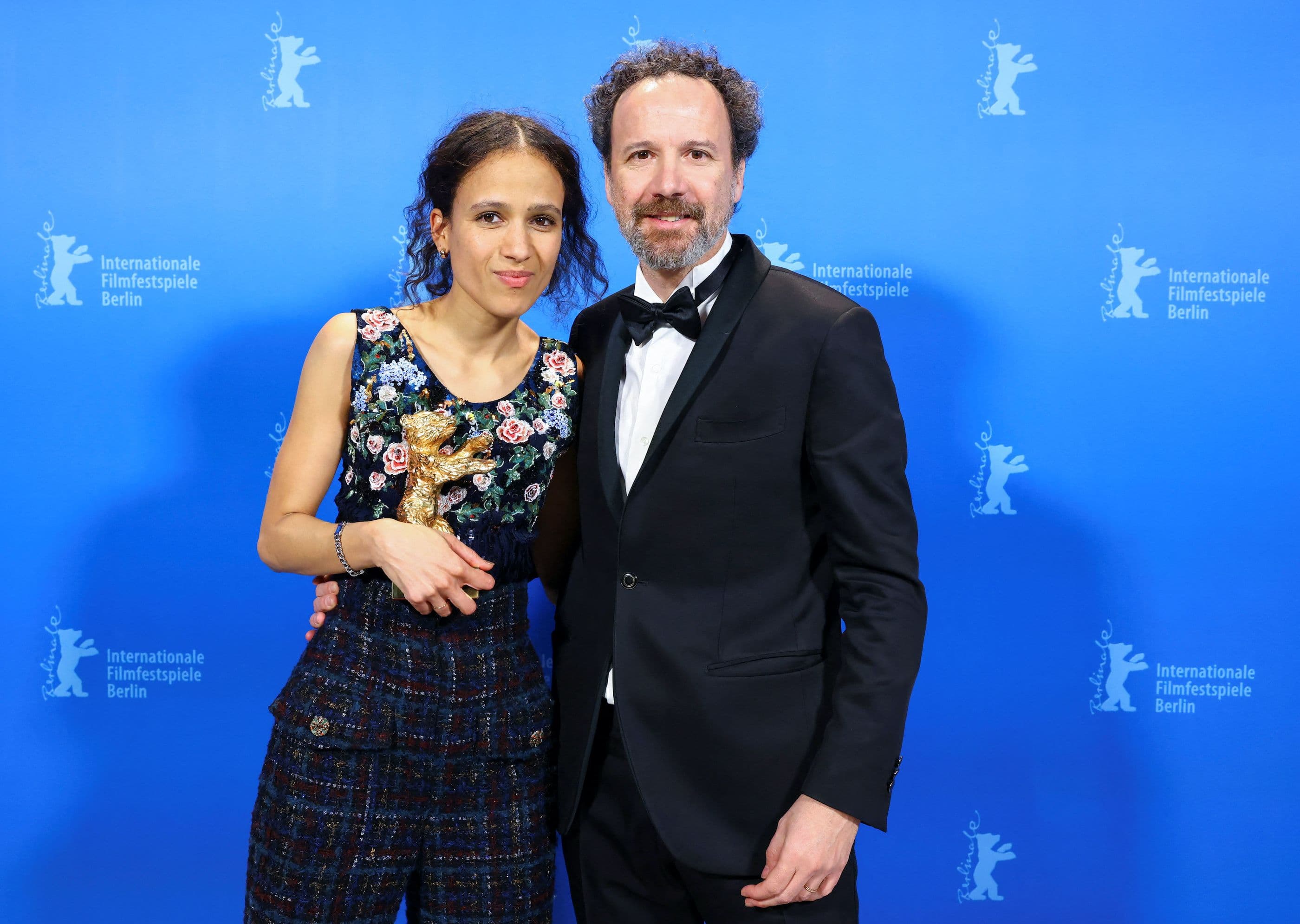La directora Mati Diop sostiene el Oso de Oro 2024 por 'Dahomey' y posa con Carlo Chatrian, codirector artístico de la Berlinale